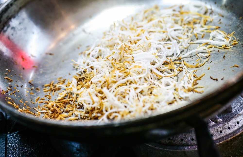 Toasted coconut in a stainless steel pan pan